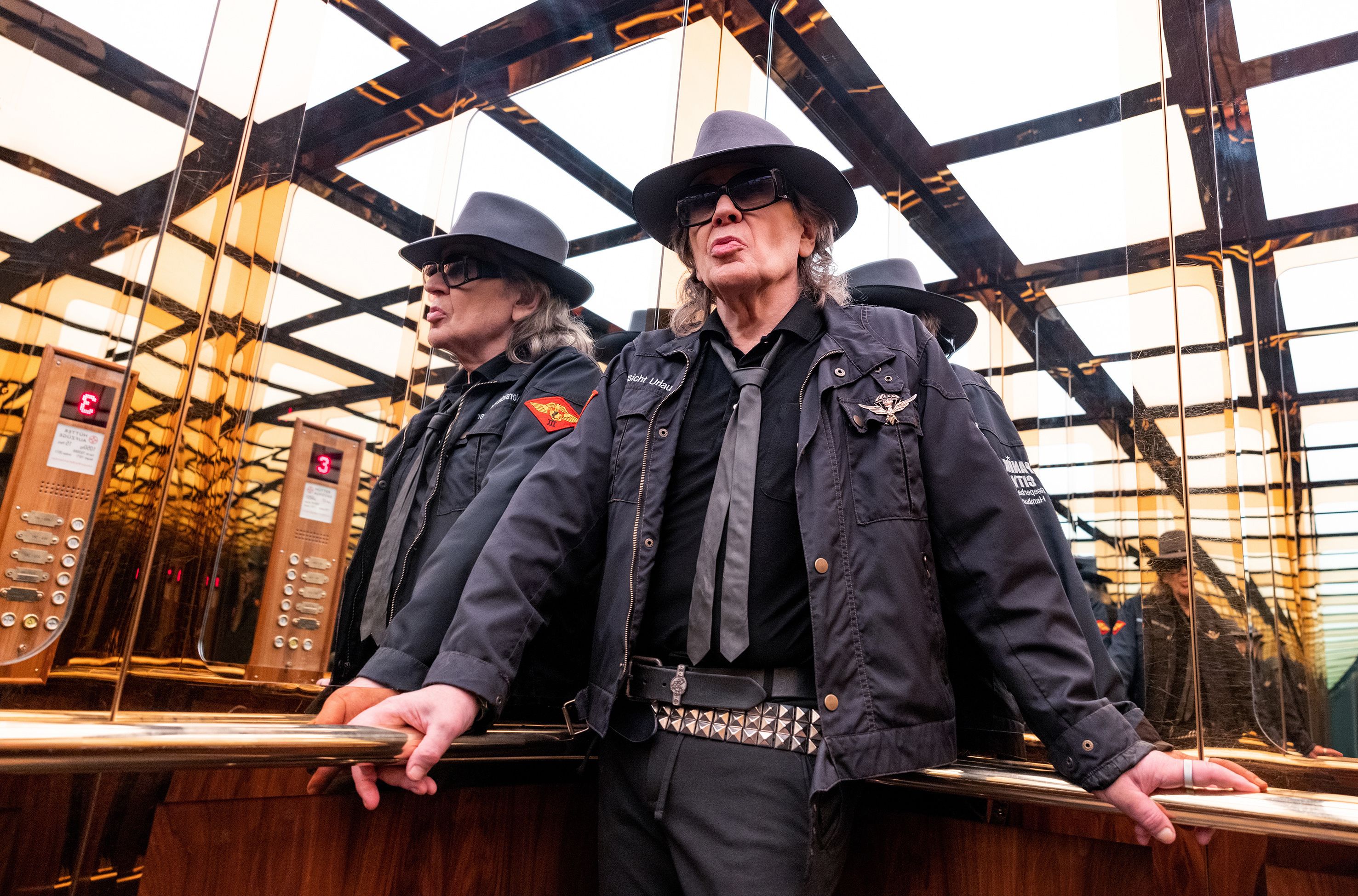 Udo Lindenberg steht in einem verspiegelten Fahrstuhl.