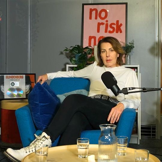 Rita Flügge-Timm sitzt lässig an einem Bistrotisch